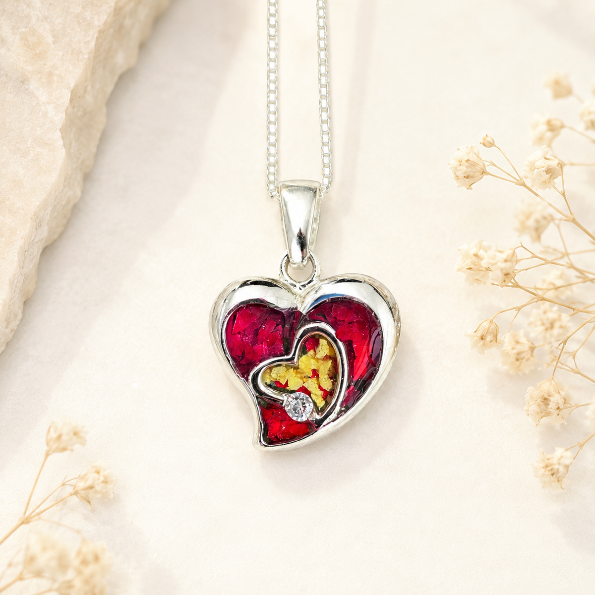 Everlasting Heart Pendant with red and yellow preserved flowers in a silver heart design.