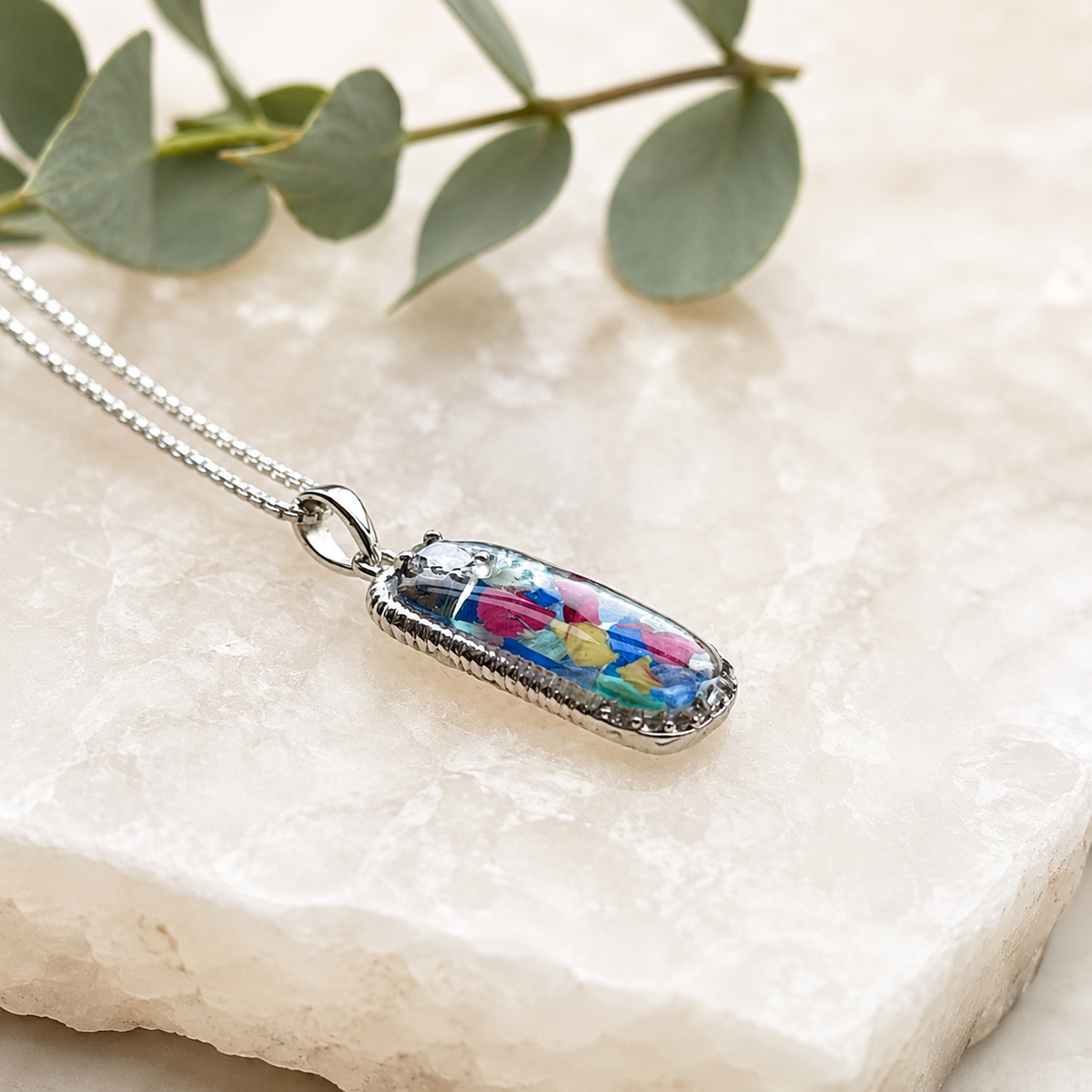 Graceful Remembrance Pendant with colorful preserved flowers shown from the side.