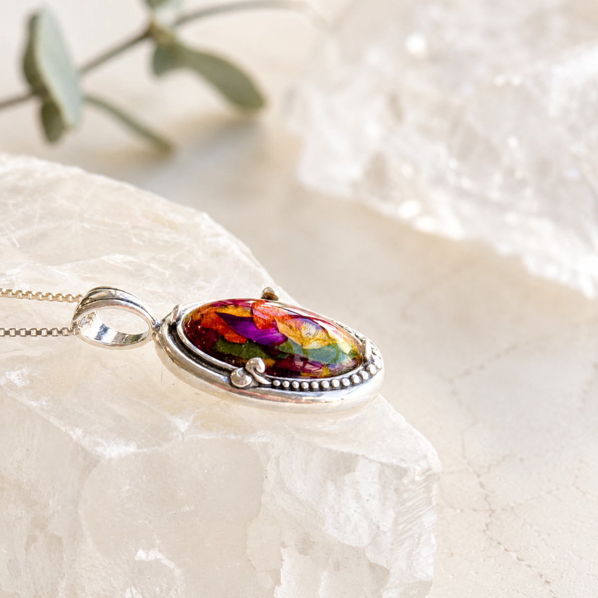 Harmony Oval Pendant with colorful preserved flowers shown from the side.
