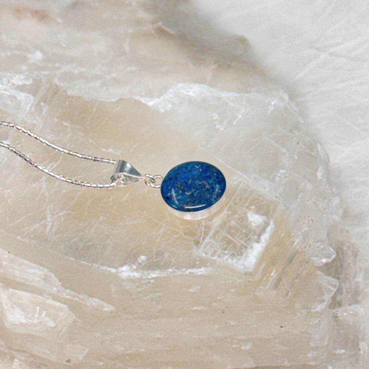 Side view of the Loyal Companion round pet ash pendant, highlighting the resin depth and sterling silver setting.