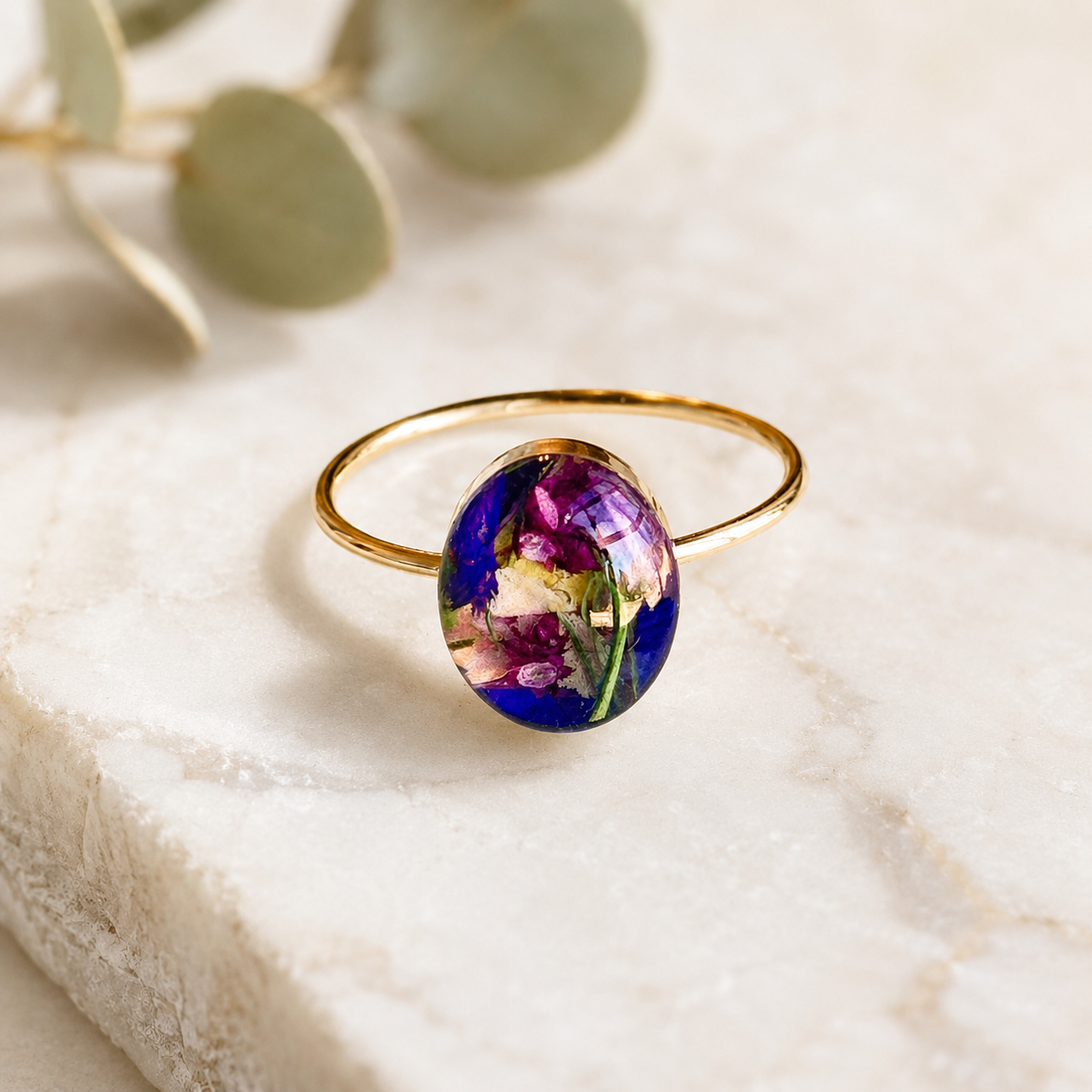 Luna Bloom Ring with colorful preserved flowers in an oval gold setting.