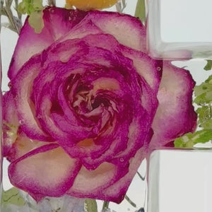 Close-up video showcasing a custom resin letter "E" embedded with real preserved flowers from a wedding bouquet or memorial arrangement. Highlights the clarity of the epoxy and the delicate detail of roses and wildflowers, perfect for remembering special moments with personalized floral keepsakes.