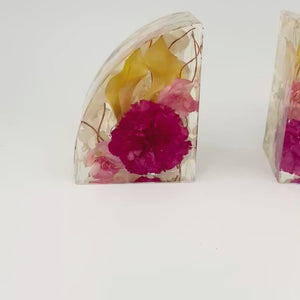 A full 360-degree video showing The Keepsake Hold resin bookends from all angles, featuring preserved yellow and pink flowers inside each handmade piece.