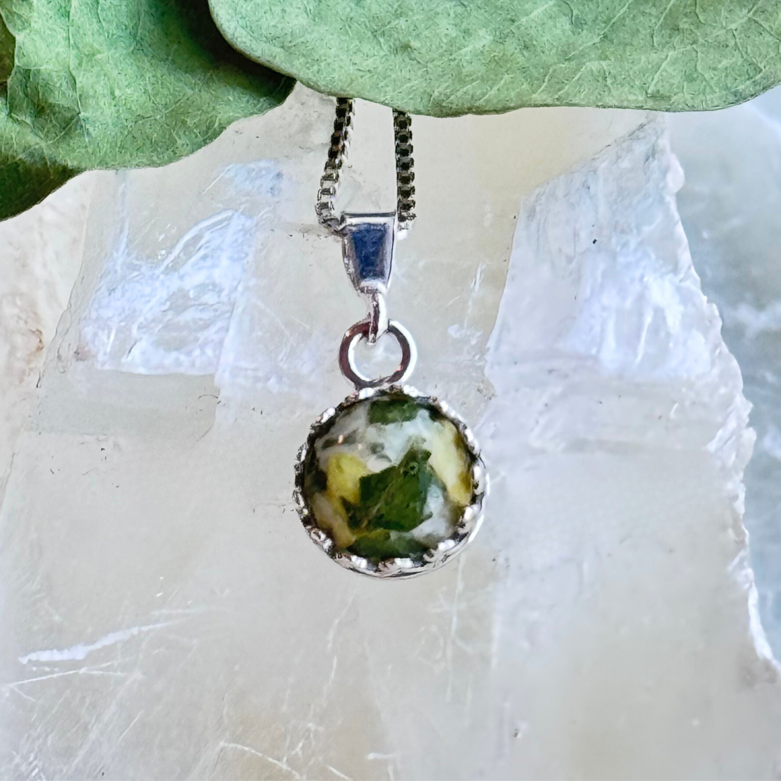 Round resin pendant with preserved flower petals in sterling silver crown setting, handmade memorial or wedding keepsake jewelry