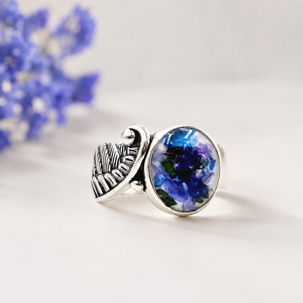 Seraphina Memorial Ring with blue and purple preserved flowers in a silver setting.