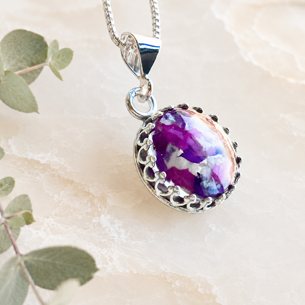 Timeless Floral Keepsake with purple and white preserved flowers in a silver oval setting.