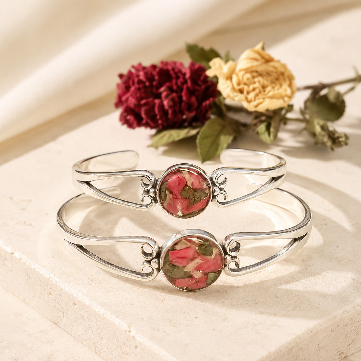 Two Unity Memorial Bracelets with pink and green preserved flowers in silver settings.