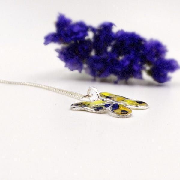 Side view of the Butterfly Keepsake Pendant showcasing the preserved flowers and sterling silver craftsmanship.