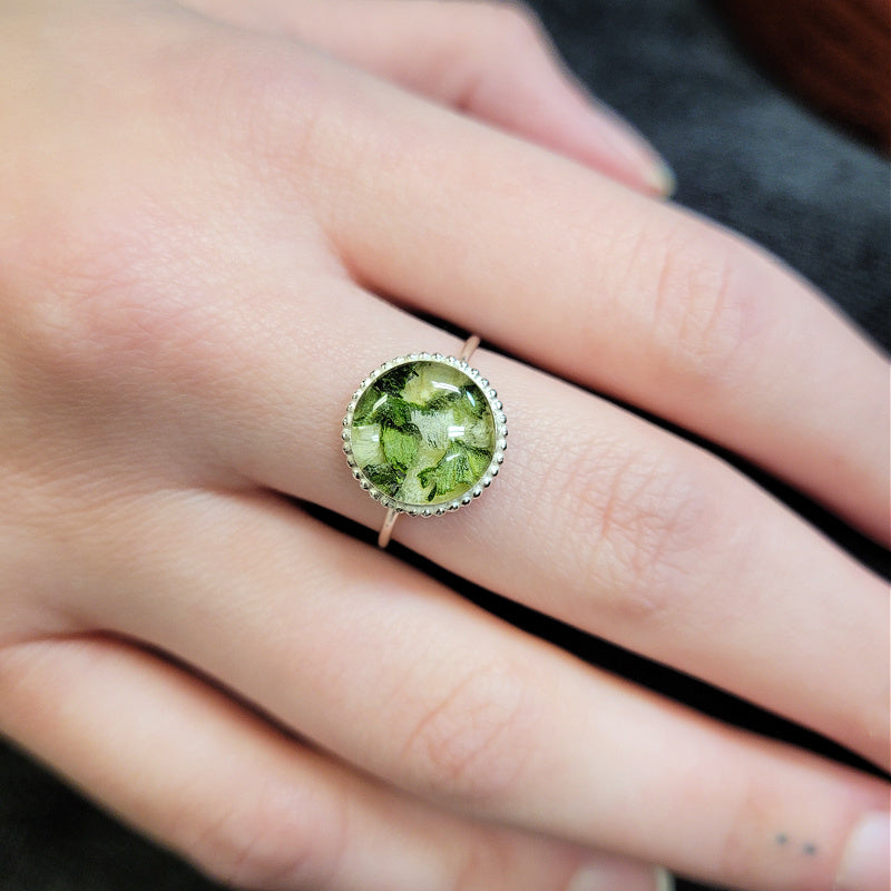 Circle of Memories Ring worn on hand, featuring a round keepsake setting handcrafted from preserved flowers or cremation ashes in sterling silver.