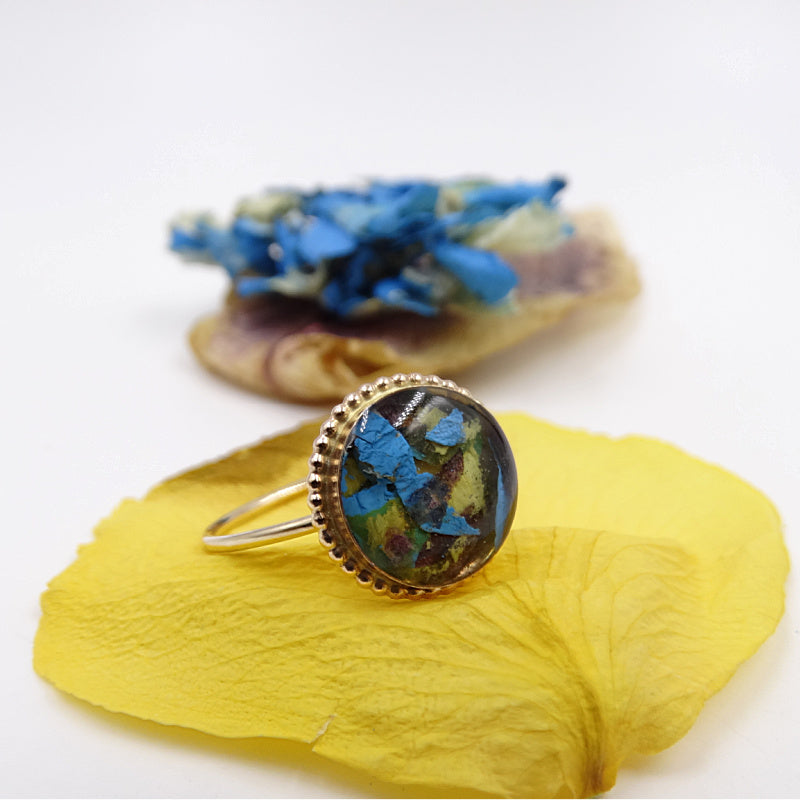 Gold-plated Circle of Memories Ring displayed with the preserved flowers used to create it.