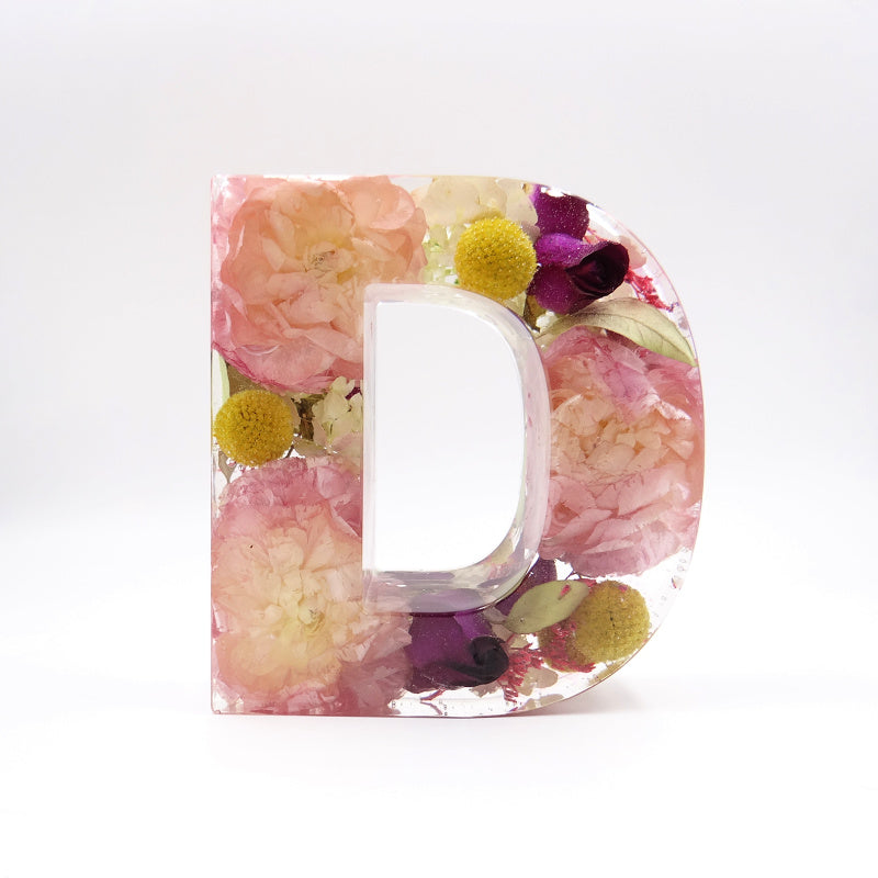 Resin letter D with vibrant pink and spring-colored preserved flowers from wedding or memorial bouquet, handmade floral keepsake