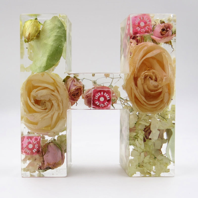 Resin letter H with preserved wedding bouquet flowers and lucky dice from Las Vegas honeymoon, personalized floral keepsake
