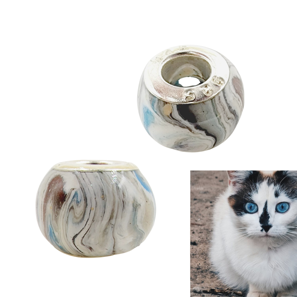 A handcrafted pet memorial bead designed to match a cat’s fur and eye color, displayed next to a photo of the pet it represents.