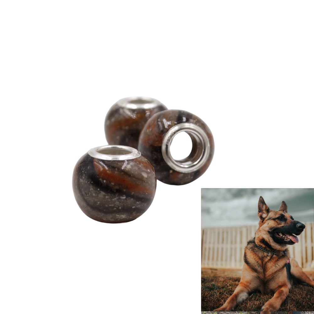 A handmade pet memorial bead designed to match a dog’s fur coloring, displayed next to a photo of the beloved pet.