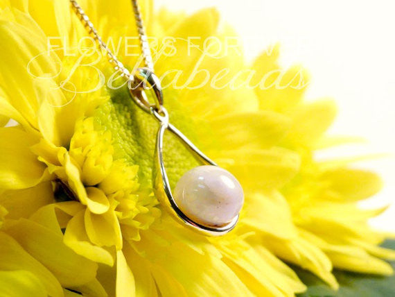 Side view of the Golden Bloom Pendant, handcrafted in solid 14K gold with preserved flowers, paired with an 18-inch gold-plated chain.