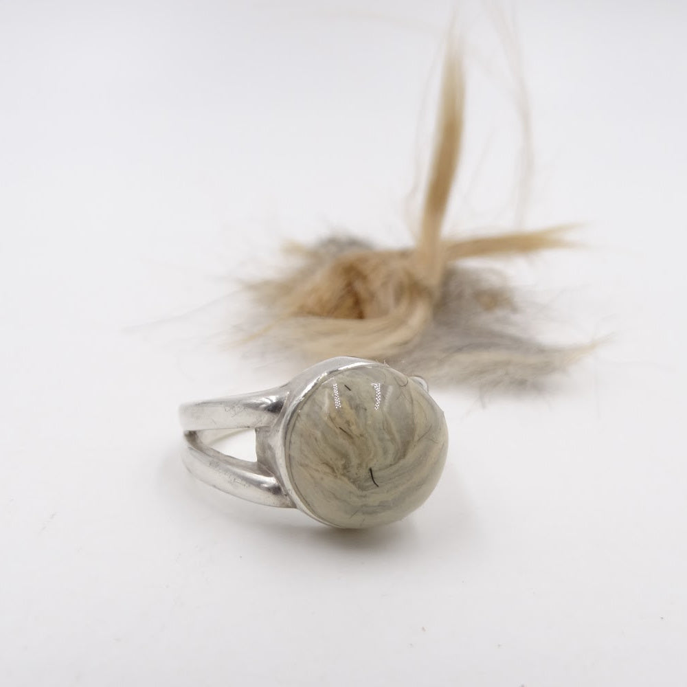 A handcrafted pet memorial ring with a soft fur background, symbolizing the connection between pet and owner.