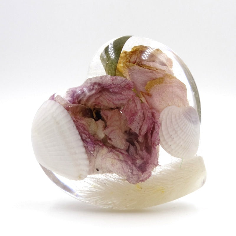 Pink rose and seashells preserved inside a large resin heart keepsake.

