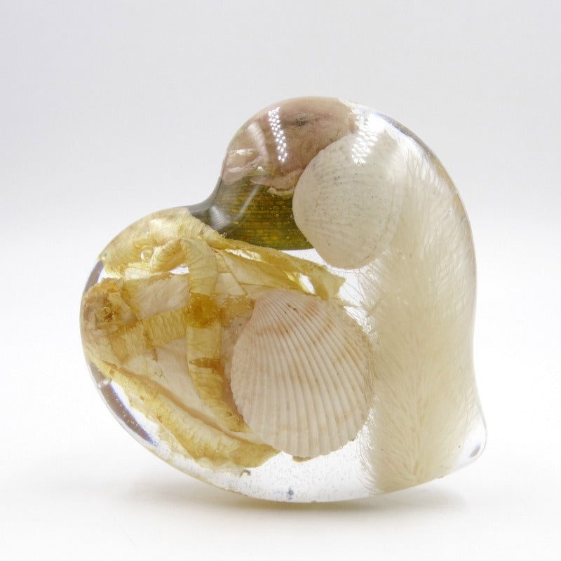 Large clear resin heart infused with white roses and delicate seashells.


