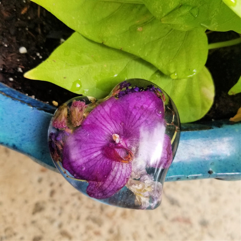 Medium resin heart keepsake with a single preserved orchid inside.