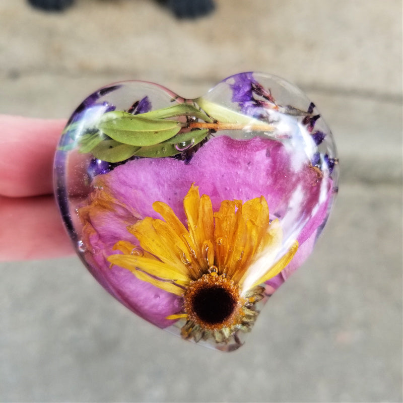 Medium-sized resin heart infused with pink petals and part of a daisy.
