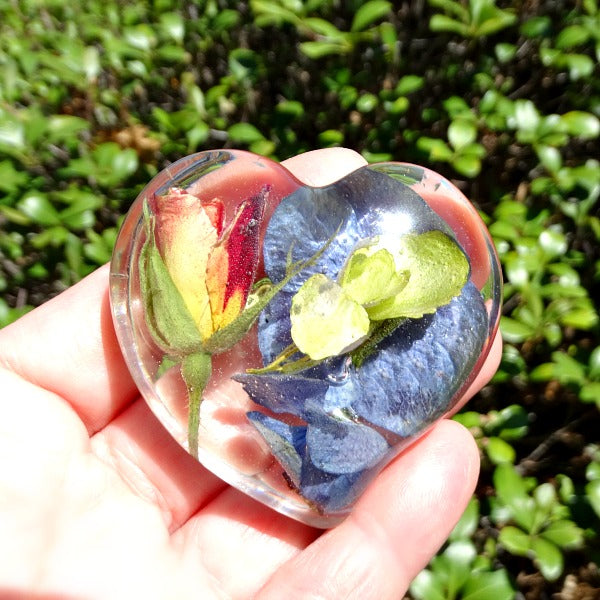Medium resin heart featuring a single rose and delicate filler flowers.