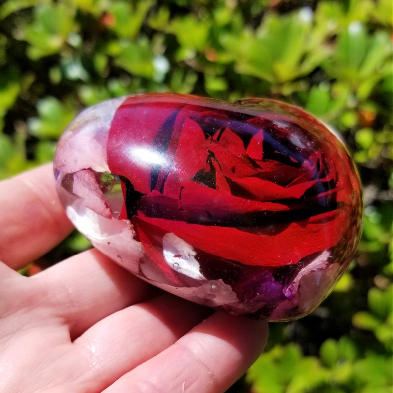 Side profile of a resin heart, showcasing a deep red preserved rose.