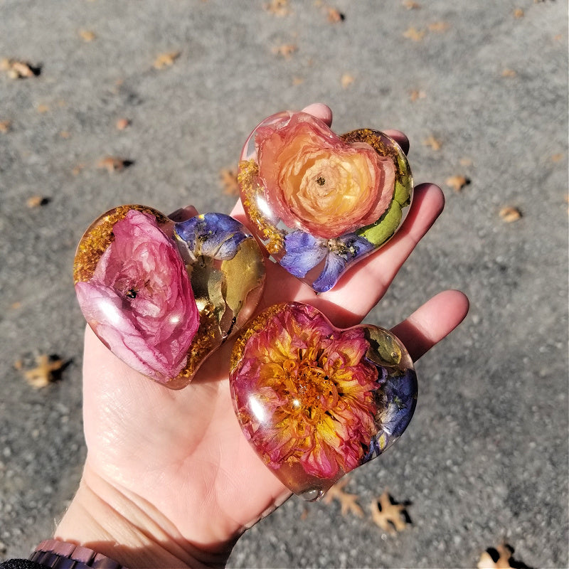 Model holding all three resin heart sizes, displaying small, medium, and large.

