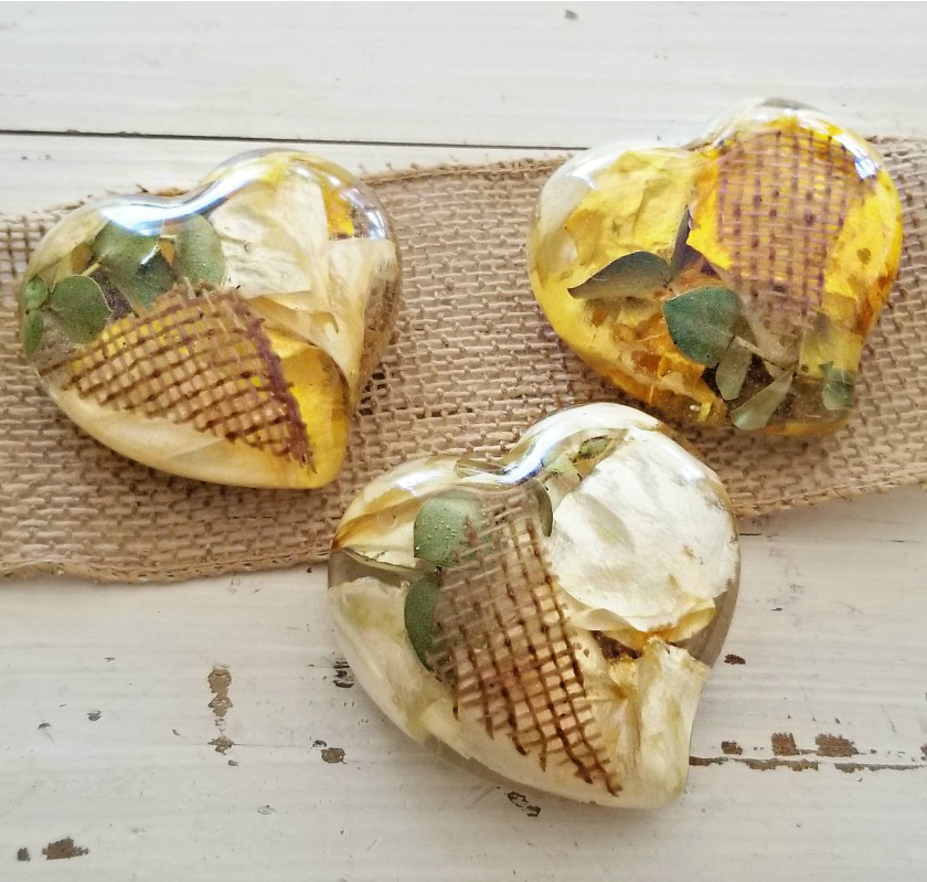 Trio of medium resin hearts tied with ribbon, surrounded by fresh flowers.