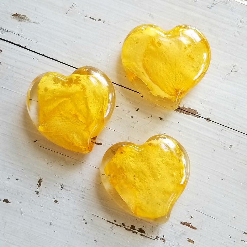 Set of three small resin hearts featuring vibrant yellow flower petals.