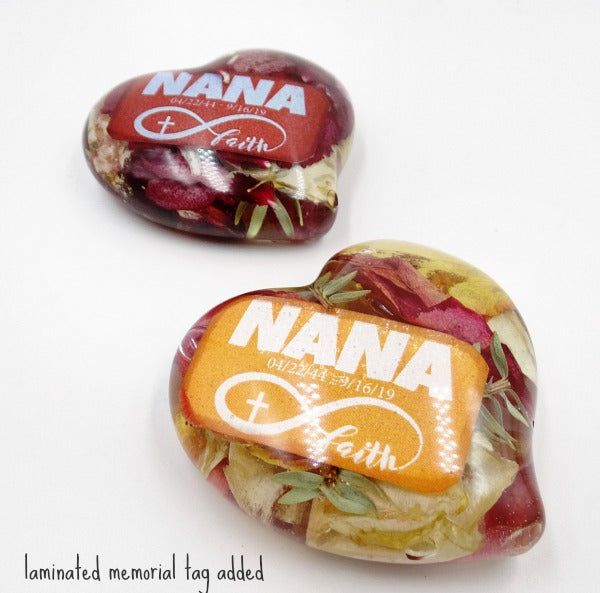 Two resin heart keepsakes featuring personalized memorabilia sent by a client.