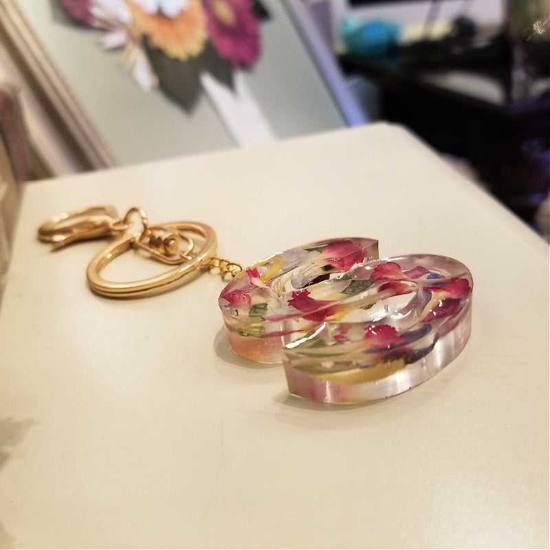 Side view of floral resin keychain showing thickness and petal layering in clear resin