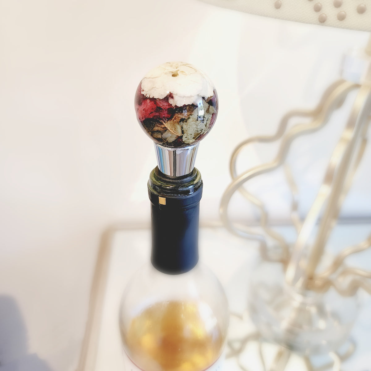 Resin wine stopper featuring preserved assorted flowers, shown on top of a wine bottle as a colorful and meaningful flower preservation keepsake.