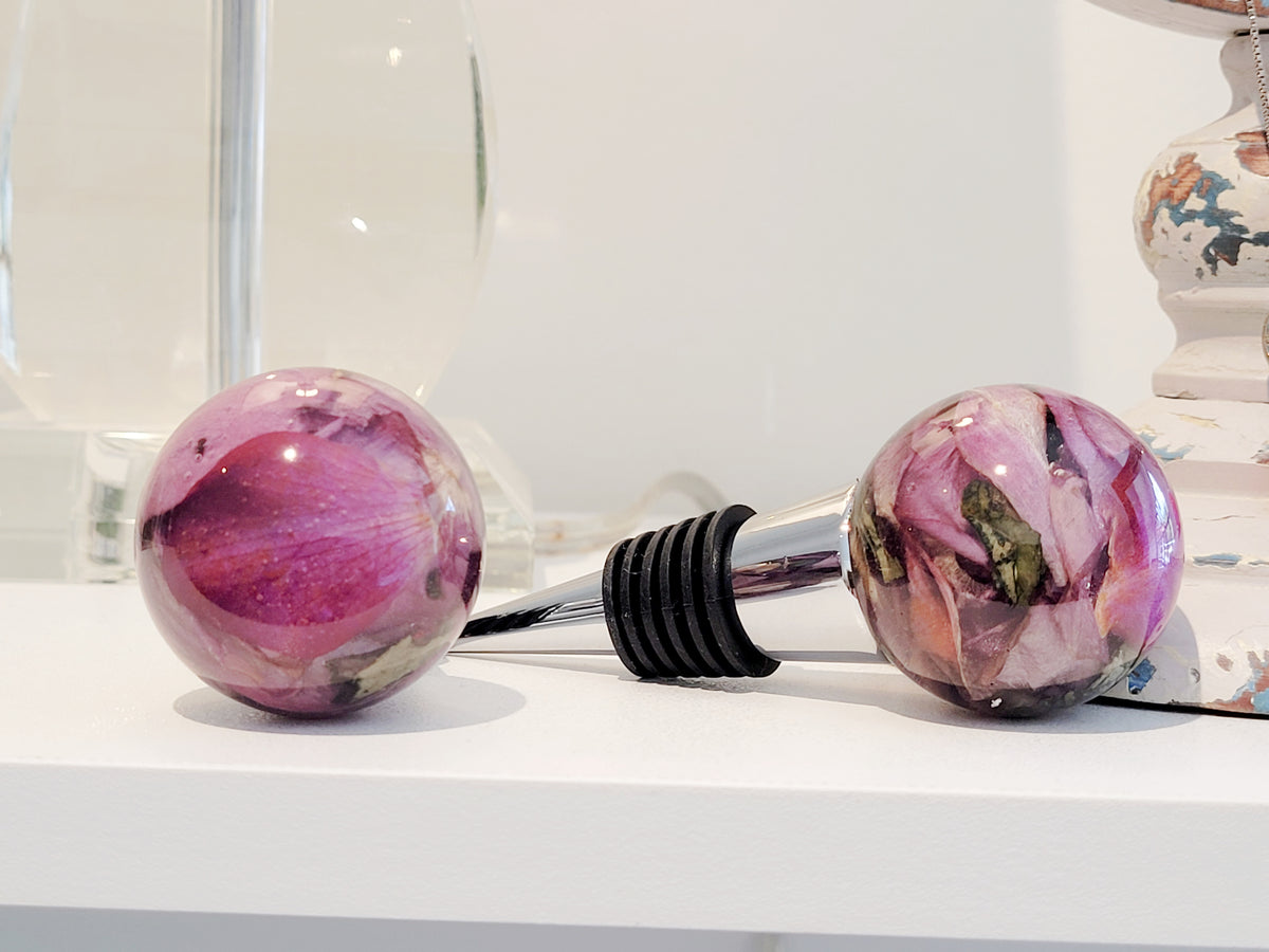 Custom wine stopper made with soft pink rose petals preserved in resin, a heartfelt keepsake for special occasions.